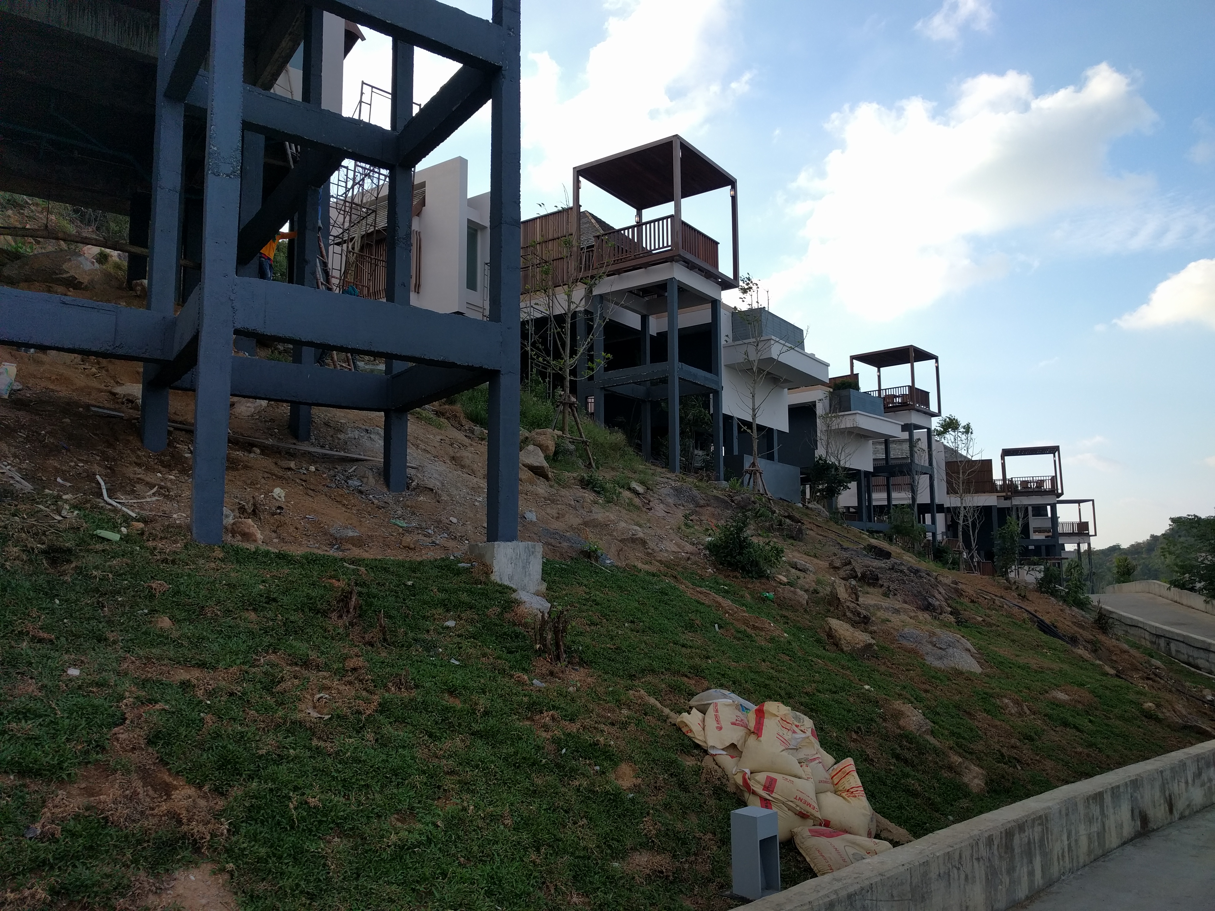 Modern villas on a hillside with construction visible.