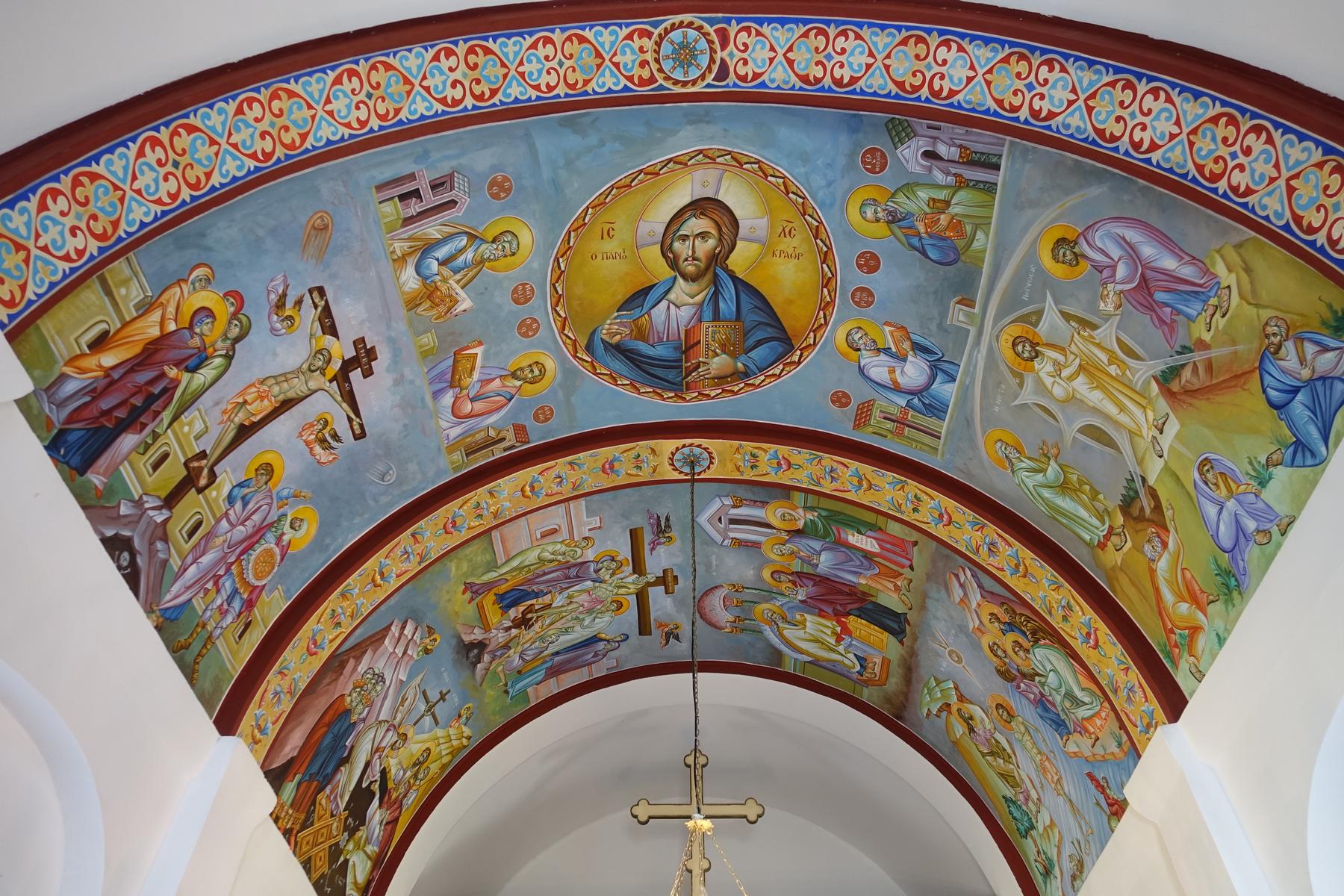 Detailed Orthodox fresco on a church ceiling featuring Christ Pantocrator surrounded by various saints and biblical events.