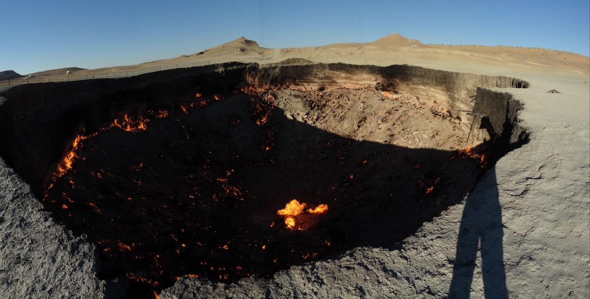 The Darvaza Gas Crater, a massive desert pit with numerous gas fires burning across its floor.