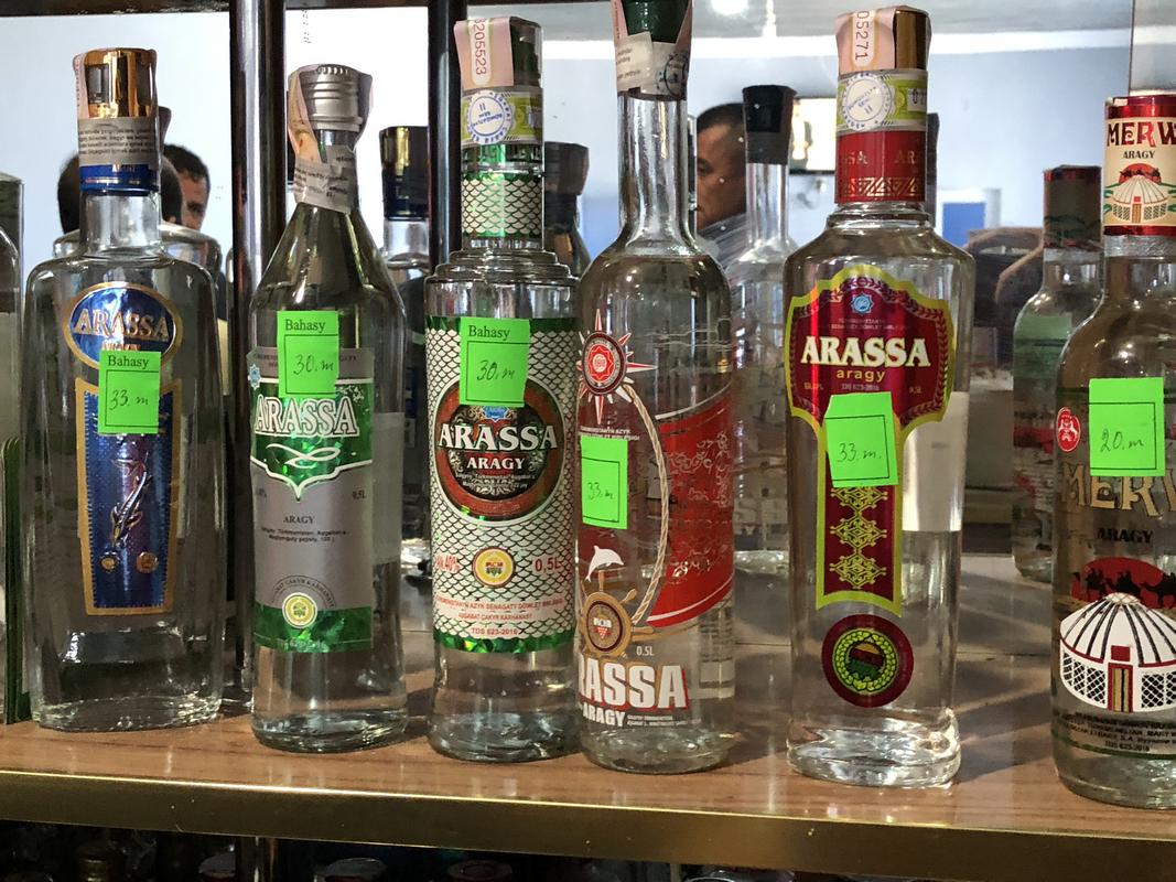 Bottles of Arassa Aragy, a Turkmen alcoholic beverage, displayed on a shelf with price tags.