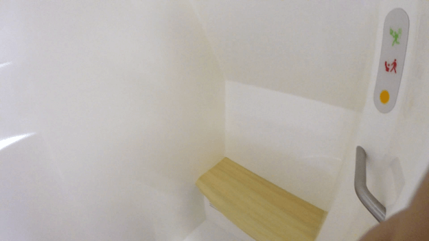 Emirates A380 First Class shower spa with wooden bench and control panel.