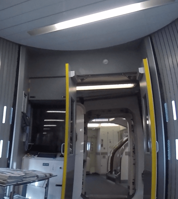 Interior of an Emirates A380 aircraft showing a galley area and an open doorway.