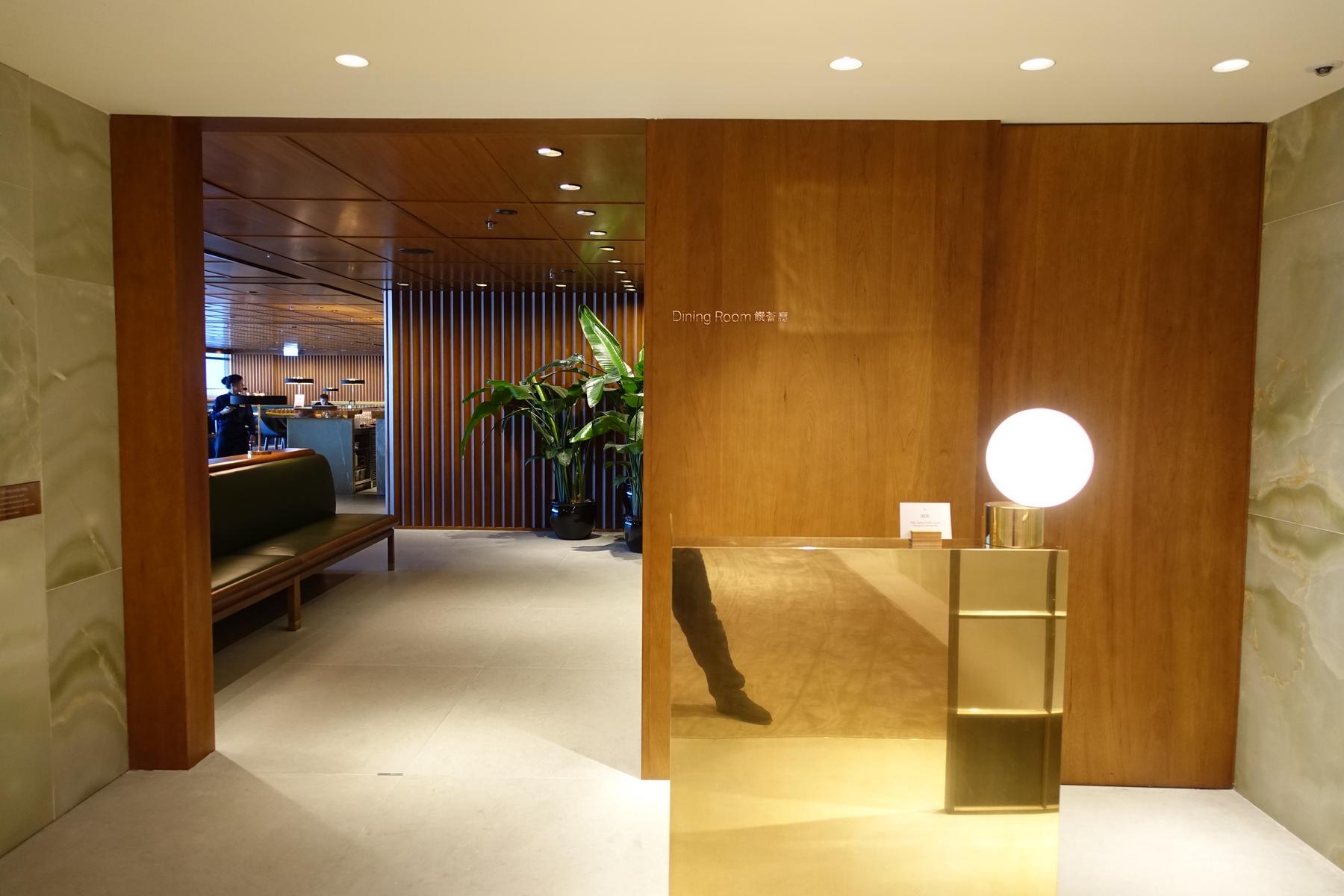 Modern entrance to the Cathay First Class Lounge Dining Room with a reflective counter and spherical lamp.