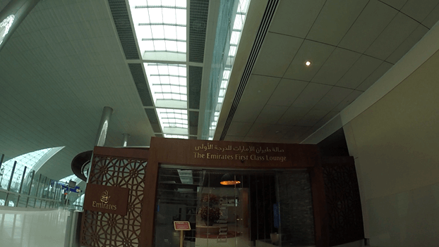 The Emirates First Class Lounge entrance in a modern airport terminal.