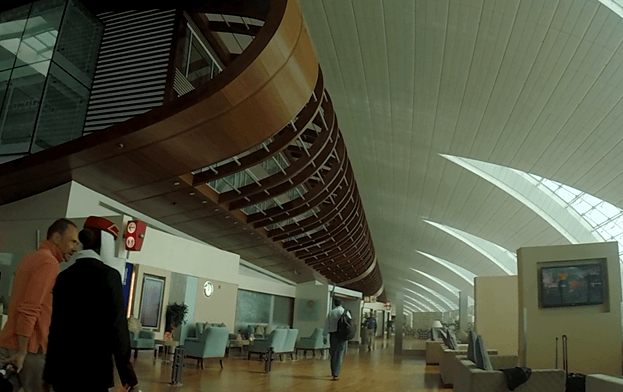 Emirates First Class lounge in Dubai, featuring a high, curved ceiling and modern seating areas.