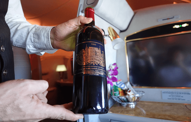 A flight attendant presents a bottle of Chateau Palmer 1995 wine in Emirates First Class.