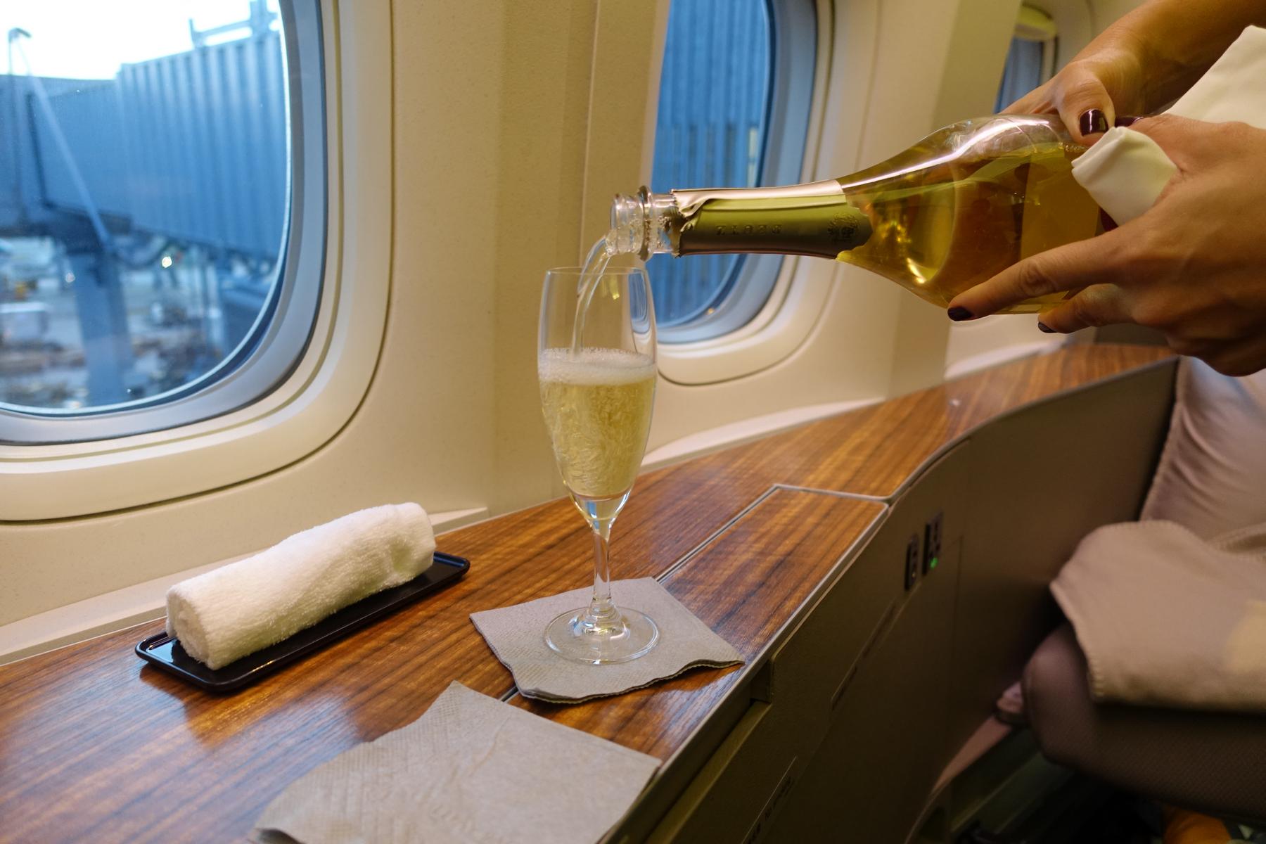 Champagne is poured into a flute glass in Cathay Pacific First Class.
