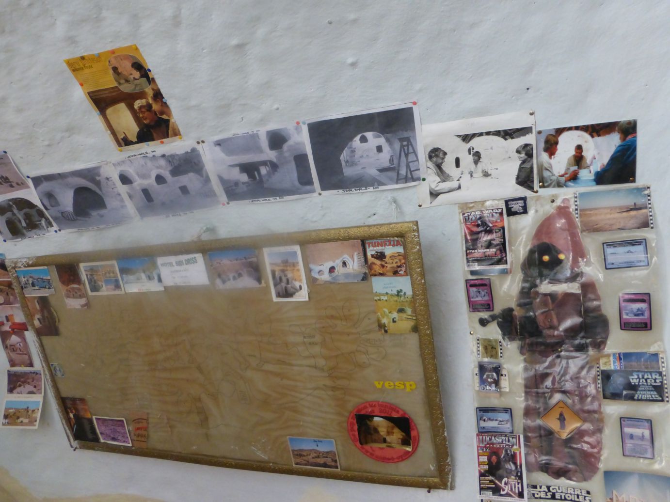 Star Wars production photos and memorabilia from Tunisian sets displayed on a wall.