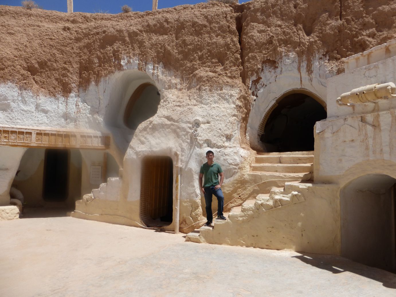 A man stands outside the distinctive cave dwellings of a Star Wars set in Tunisia.