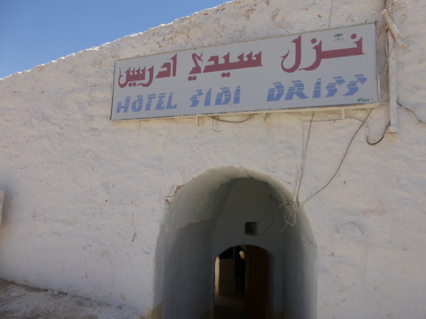 The white exterior of Hotel Sidi Driss, the Star Wars Lars Homestead, with its distinctive arched entrance.
