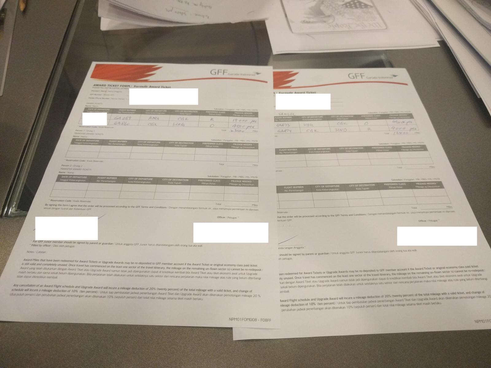 Two GarudaMiles Award Ticket Forms are shown, detailing first class bookings.