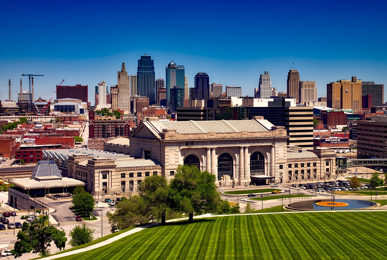 An elevated view of Kansas City, showing Union Station, a green lawn, and the downtown skyline.